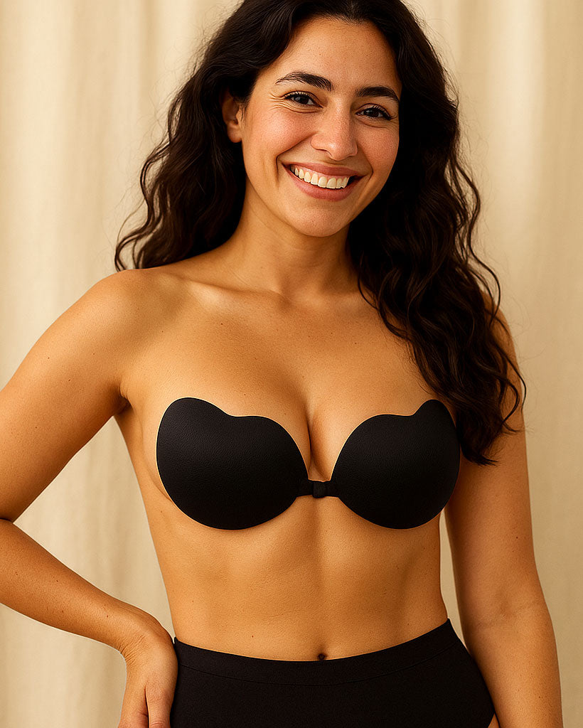 Woman wearing a black strapless bra against a beige background