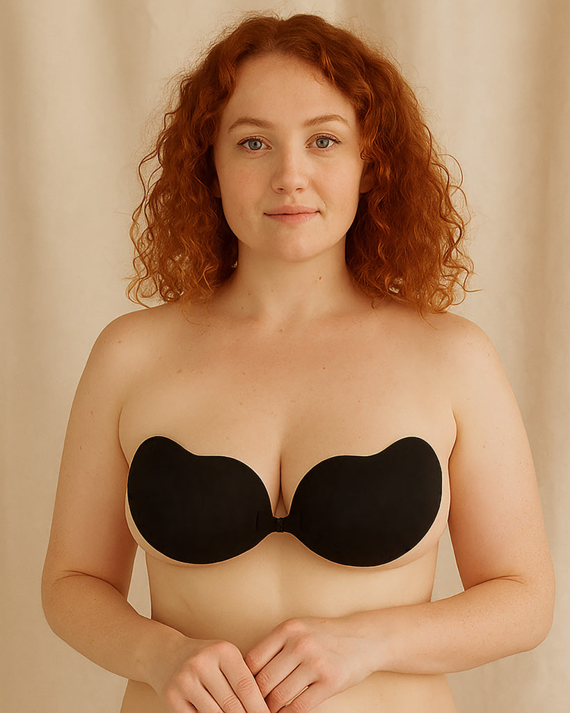 Woman wearing a black strapless bra against a beige background